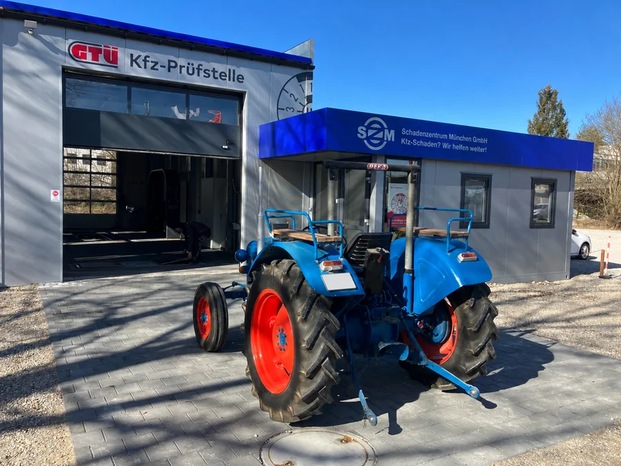 Blauer Oldtimer-Traktor vor dem SZM-Gebäude in Ismaning